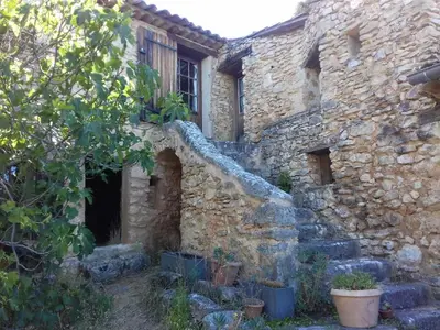 an old stone building with a staircase in front of it at Le Jas des aiguiers in Saint-Saturnin-les-Apt