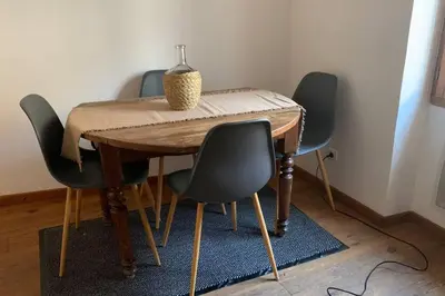 a dining room table with four chairs and a vase on it at Duplex à Monteux centre, 5 couchages distincts, LOCAL VELOS in Monteux