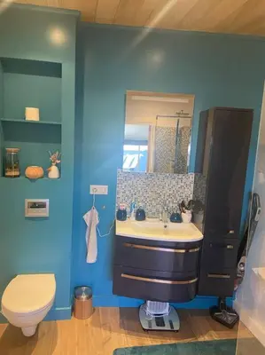 a blue bathroom with a sink and a toilet at Appartement duplex toit terrasse in Apt