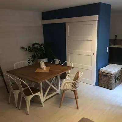 a wooden table and chairs in a room with a door at Appartement duplex toit terrasse in Apt