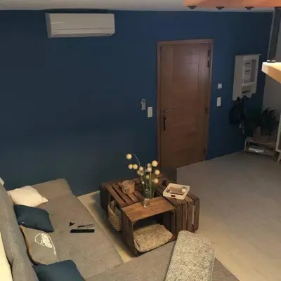 a living room with a couch and a table with flowers at Appartement duplex toit terrasse in Apt