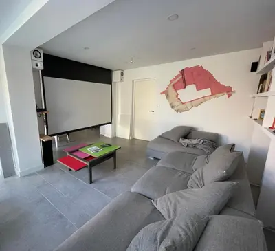 a living room with a couch and a large screen at Maison moderne Avignon pour 6 pers Piscine privée in Avignon