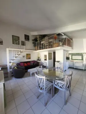 a living room with a table and chairs and a couch at Appartement au Cœur de la Sorgue in LʼIsle-sur-la-Sorgue