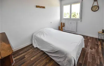 a bedroom with a bed with white sheets and a window at Nice Apartment In Carpentras With Wifi in Carpentras