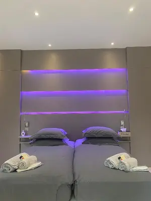 a bedroom with two beds with purple lights on it at La Bastide des Rosiers in Mallemort