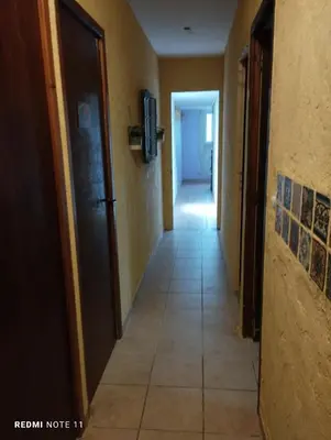 a hallway of a hotel with a door and a tile floor at Chambre d hôtes en Provence, au pied du Luberon, les Coquelicots in La Tour-dʼAigues