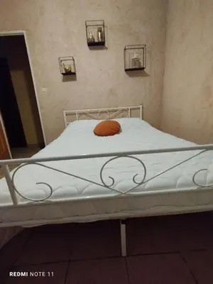 a hospital bed with a orange pillow on it at Chambre d hôtes en Provence, au pied du Luberon, les Coquelicots in La Tour-dʼAigues
