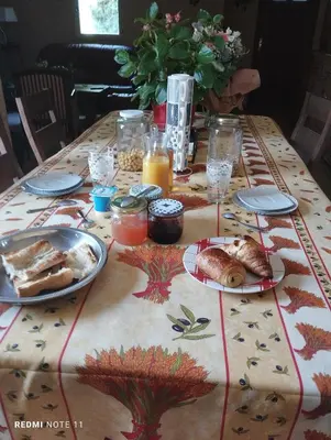 a table with a table cloth with food on it at Chambre d hôtes en Provence, au pied du Luberon, les Coquelicots in La Tour-dʼAigues