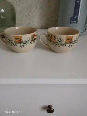 two cups sitting on a counter next to a microwave at Chambre d hôtes en Provence, au pied du Luberon, les Coquelicots in La Tour-dʼAigues