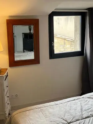a bedroom with a mirror and a bed and a window at La terrasse de Caromb face au Mont VENTOUX maison avec clim in Caromb