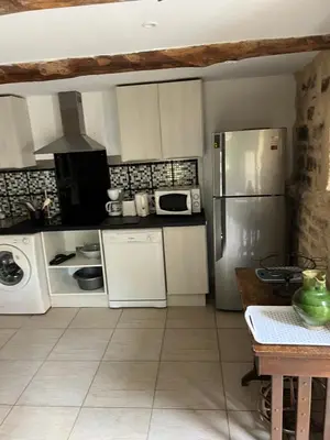 a dining table with two chairs and a stone wall at La terrasse de Caromb face au Mont VENTOUX maison avec clim in Caromb