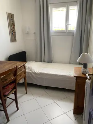 a bedroom with a bed and a desk and a window at VILLA MIREILLE CALME ARBOREE PISCINE SANS VIS A VIS SECURISEE in Morières-lès-Avignon