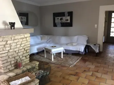 a living room with a white couch and a fireplace at VILLA MIREILLE CALME ARBOREE PISCINE SANS VIS A VIS SECURISEE in Morières-lès-Avignon