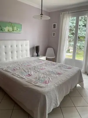 a bedroom with a bed with a white bedspread and a window at VILLA MIREILLE CALME ARBOREE PISCINE SANS VIS A VIS SECURISEE in Morières-lès-Avignon