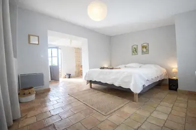 a white bedroom with a bed and a fireplace at Studio Est - 30 m2 Domaine viticole Château Barbebelle - Jardin & Boulodrome partagés in Rognes