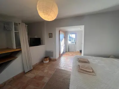 a dining room table with chairs and a kitchen at Studio Est - 30 m2 Domaine viticole Château Barbebelle - Jardin & Boulodrome partagés in Rognes