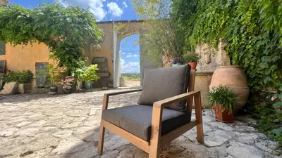 a chair sitting on a stone ground in a yard at Mas Saint-Genies in Venasque