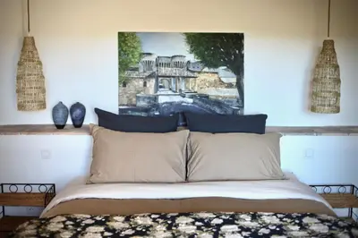 a bedroom with a bed with a painting on the wall at Mas Saint-Genies in Venasque