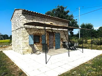 a small stone house with a large patio at Le Cabanon des Lavandes entre Mont Ventoux et Luberon in Sault-de-Vaucluse