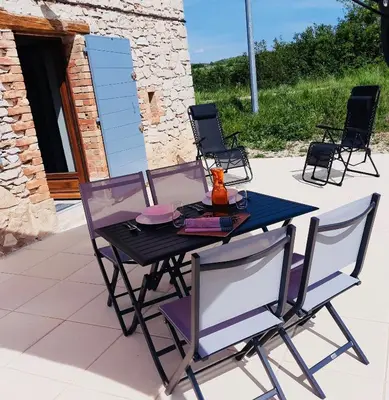 a black table and chairs on a patio at Le Cabanon des Lavandes entre Mont Ventoux et Luberon in Sault-de-Vaucluse