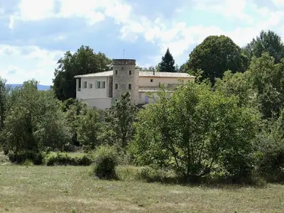 a building in the middle of a field with trees at La Grisonne - Chalet3 in Revest-du-Bion
