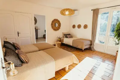 a bedroom with two beds and a window at Villa des Baumes in Cornillon-Confoux