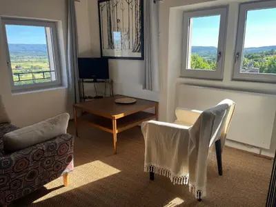a living room with a table and chairs and windows at Magic views in paradise in Joucas