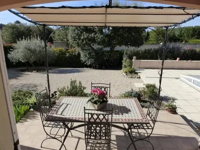 a table and chairs under an umbrella on a patio at Gîte Les Hauts Sauviers avec piscine et sauna in Bédoin