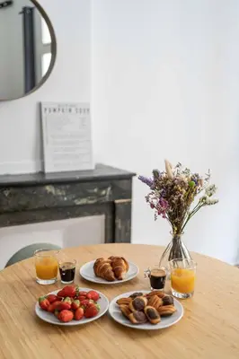 two plates of food on a wooden table with drinks at Studio Mezzanine Aumône Vieille in Aix-en-Provence
