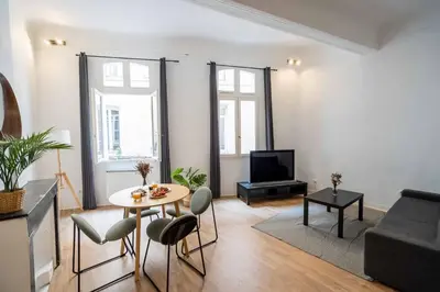 a living room with a table and a tv at Studio Mezzanine Aumône Vieille in Aix-en-Provence