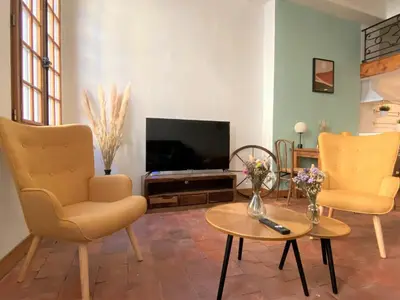 a living room with two chairs and a television at Studio Mezzanine Mairie in Aix-en-Provence
