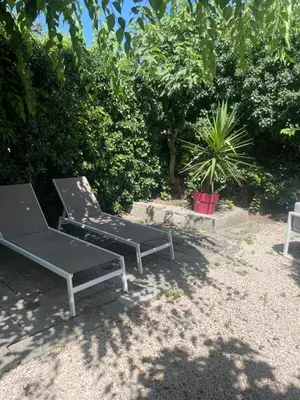 a couple of benches sitting in a yard at Appartement avec jardin en ville in LʼIsle-sur-la-Sorgue