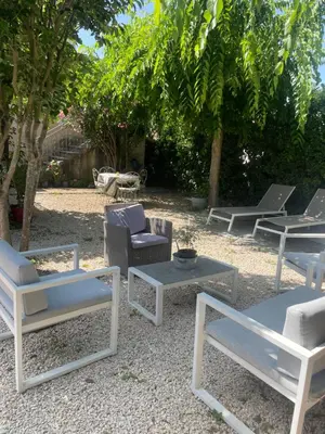 a group of chairs and tables in a yard at Appartement avec jardin en ville in LʼIsle-sur-la-Sorgue