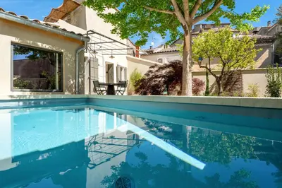 a swimming pool in front of a house at La Fontaine aux Fées in Lagnes