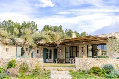 a home in the desert with a stone wall at Mas La Bergerie in Eygalières