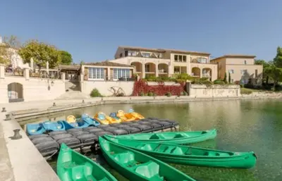 a group of green boats in a body of water at Appartement domaine du golf Pont Royal Provence avec PARC AQUATIQUE in Mallemort