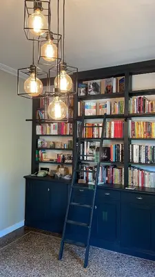 a book shelf filled with books with a ladder at La Pavoyère in Mormoiron