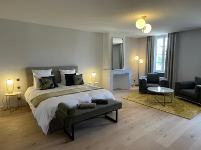 a bedroom with a large bed and a living room at La Pavoyère in Mormoiron