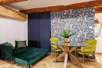a dining room with a glass table and green chairs at Au cœur d’Aix-en-Provence in Aix-en-Provence