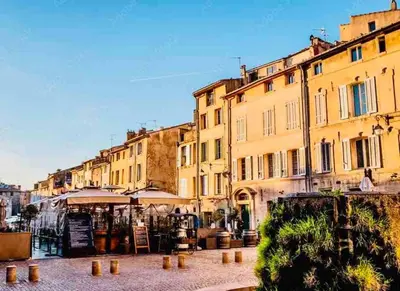 a group of buildings with tables and umbrellas on a street at Au cœur d’Aix-en-Provence in Aix-en-Provence