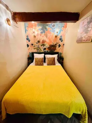 a bedroom with a yellow bed with a yellow blanket at Au cœur d’Aix-en-Provence in Aix-en-Provence
