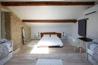 a bedroom with a bed and a desk in a room at Superbe Mas contemporain au pied du Luberon in Cheval-Blanc
