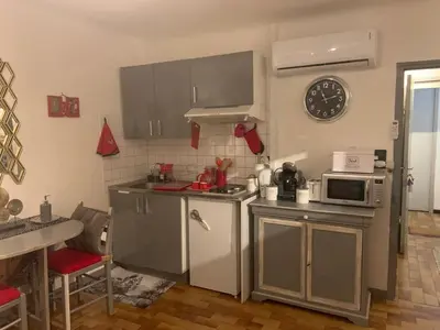 a kitchen with stainless steel appliances and a clock on the wall at Studio de Luxe Aix en Provence in Aix-en-Provence