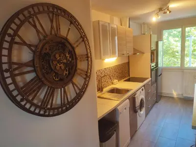 a kitchen with a large clock on the wall at Grand appartement de charme calme et lumineux parking compris in Aix-en-Provence