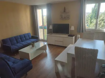 a living room with a blue couch and a tv at Grand appartement de charme calme et lumineux parking compris in Aix-en-Provence