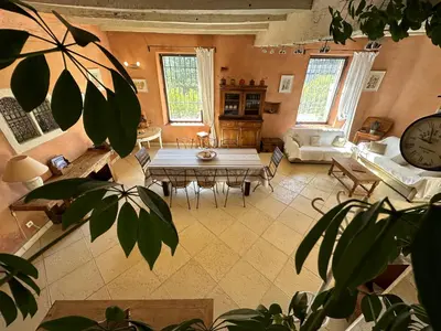 a large living room with a table and a clock at Le Domaine de Piedmoure, Gîtes et chambres, piscine, terrasses privatives in Sault-de-Vaucluse