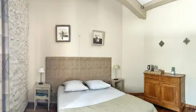 a bedroom with a bed and a wooden dresser at Le Domaine de Piedmoure, Gîtes et chambres, piscine, terrasses privatives in Sault-de-Vaucluse