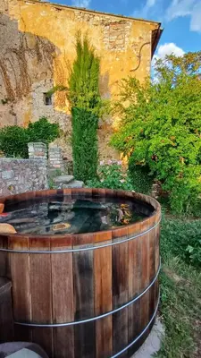 a wooden hot tub in front of a building at Maison Porte Heureuse in Roussillon