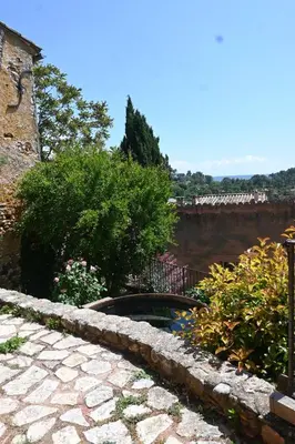 a garden with a stone walkway next to a building at Maison Porte Heureuse in Roussillon