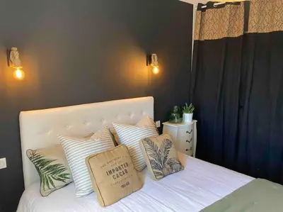a bedroom with a white bed with pillows on it at Villa les Romarins in Saint-Didier